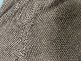 close up of a person wearing a gray sweater and a black tie