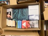 many books in a cardboard box on a shelf