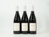 trois bouteilles de vin sont alignées sur une table