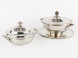 deux assiettes et soucoupes en métal argenté posées sur un plateau blanc