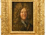 portrait of a man with curly hair in a gold frame