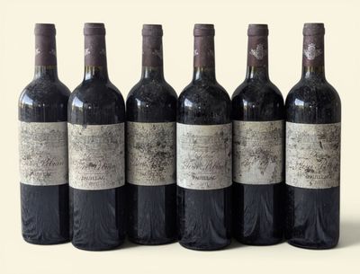 six bottles of wine are lined up in a row on a white surface