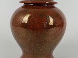 an image of a red vase with a lid sitting on a white surface