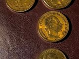 four different coins sitting on top of a brown leather surface