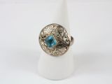 a close up of a ring with a blue stone in it