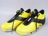 a close up of a pair of yellow and black shoes on a white surface