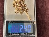 une balance surmontée d'une chaîne en or, posée sur une surface marron