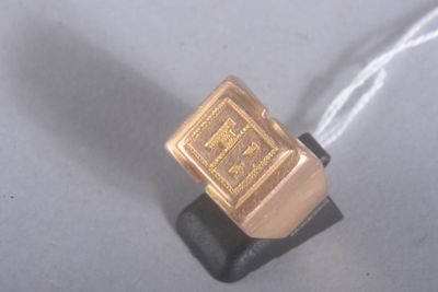 une photo d'une bague en or posée sur un socle noir