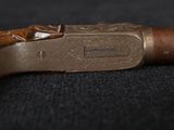 an old pipe with a wooden handle sitting on top of a black surface