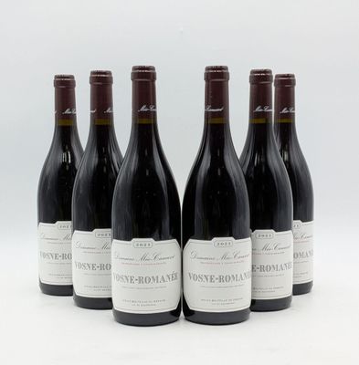 six bouteilles de vin sont alignées sur une surface blanche