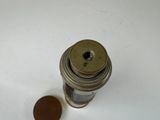a coin sitting next to a small metal object on a table