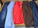 quatre paires de jeans dans une boîte posée par terre