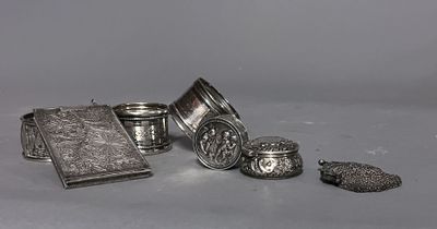 plusieurs objets en argent posés sur une table, à côté d'un livre et d'autres objets
