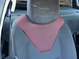 the back seat of a car with a pink seat pad on it