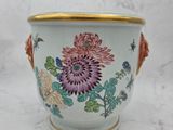 a vase with flowers painted on it sitting on a table