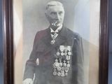 framed photograph of a man in a military uniform in front of a blue wall
