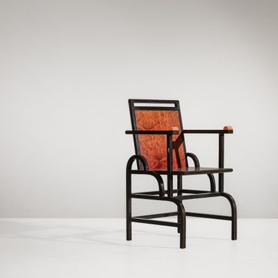 an image of a black chair with a red cushion on top of it