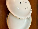 a white bowl with a lid sitting on a wooden table