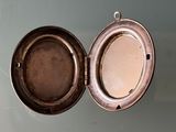 a small silver box with a silver lid on a table