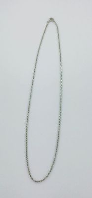un gros plan d'un collier sur une surface blanche avec un fond blanc