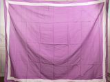 purple and white quilt hanging on a clothes line in a room
