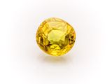 a yellow sapphire stone on a white background