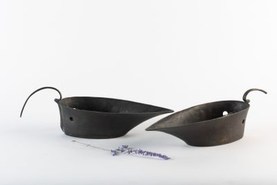 two black pots with handles on a white surface