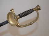 a gold colored sword with a black handle on a white background