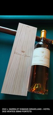 une bouteille de vin posée à côté d'un couteau sur une table