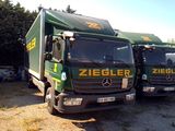 deux camions verts garés l'un à côté de l'autre sur un parking