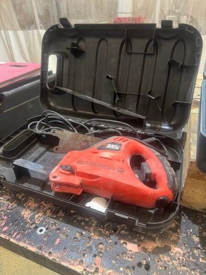 a red cordless tool in a black case on a table