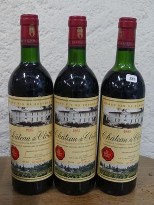 trois bouteilles de vin rouge posées sur une table en bois