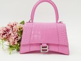 a pink handbag with a flower on a white background