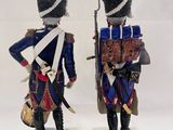 two figurines of soldiers dressed in military uniforms stand on wooden bases