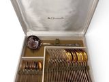 a silver case with silverware in it on a white surface