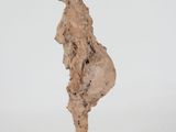 sculpture of a woman standing on a base on a white surface
