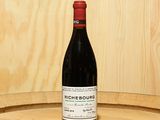 a bottle of wine sitting on top of a barrel