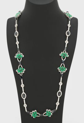 a necklace with green and white beads on a mannequin