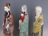 three chinese figurines of three men and a woman