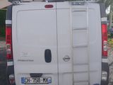 a white van parked in a parking lot with a ladder on the back of it