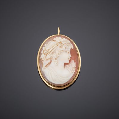 a gold and shell cameo of a woman in profile