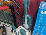un aspirateur et un sac posés par terre à côté d'autres objets