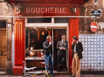 deux hommes debout devant un restaurant, avec un vélo
