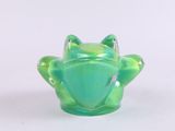 a green glass frog sitting on top of a table