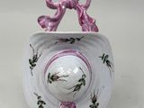 a small white bowl with a pink bow on it