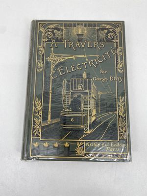 un vieux livre posé sur une table blanche à côté d'un mur blanc