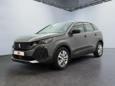 Une voiture grise est garée dans une grande pièce au sol noir.