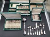 many silverware in a green case on a table