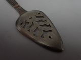 a spoon with a fish design on it sitting on a table