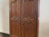 an old wooden armoire with carvings on the top of it